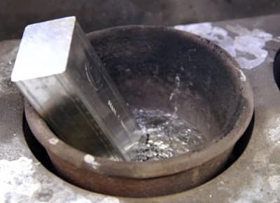 Babbitt pot with a fresh ingot being melted in